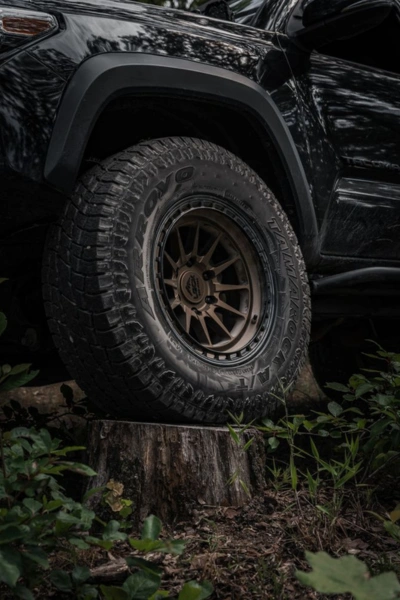 Close-up of a rugged off-road tire on a black truck — Competition Wheels San Antonio Texas specializes in durable fitments for lifted builds.