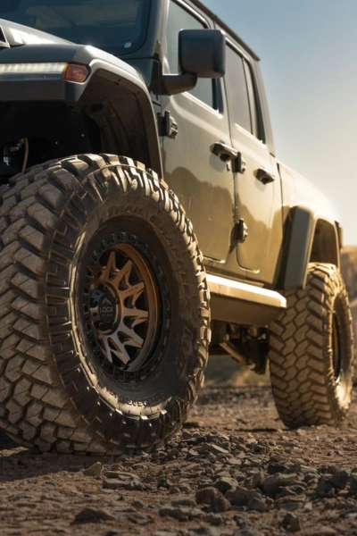 Lifted Jeep Gladiator with oversized wheels and dirt-covered tires — Competition Wheels San Antonio Texas supports off-road and Jeep builds.